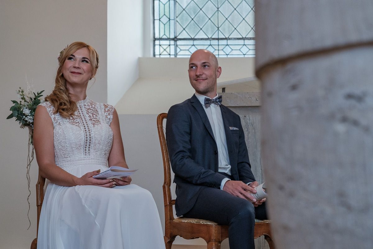 Anna und Jonas sitzen nebeneinander vor dem Altar