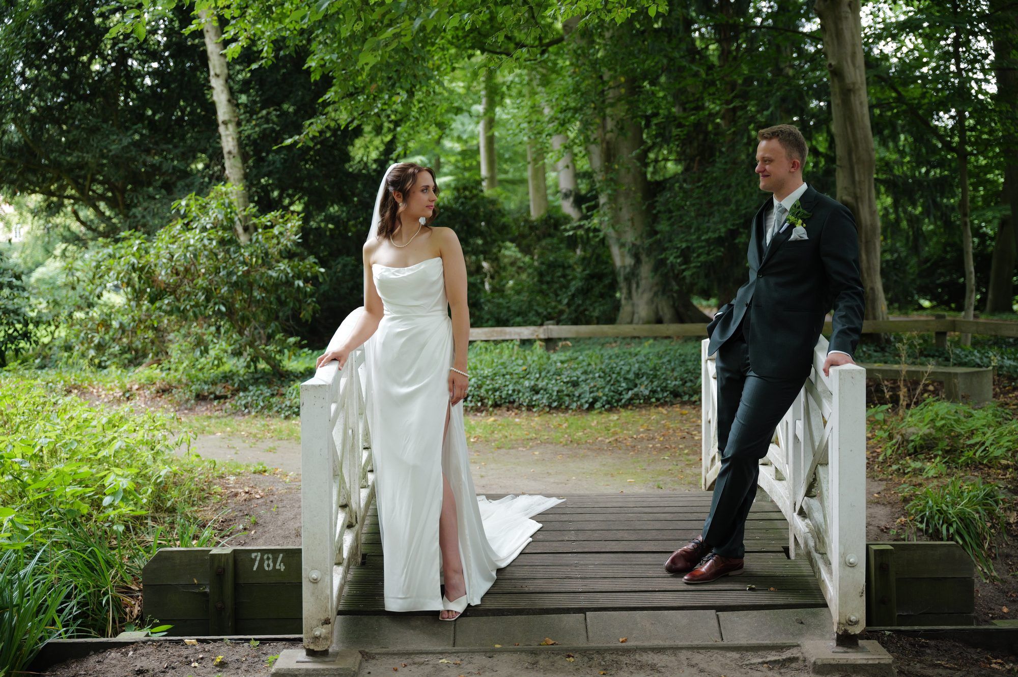 Cestina und Tim auf einer kleinen weißen Holzbrücke im Park