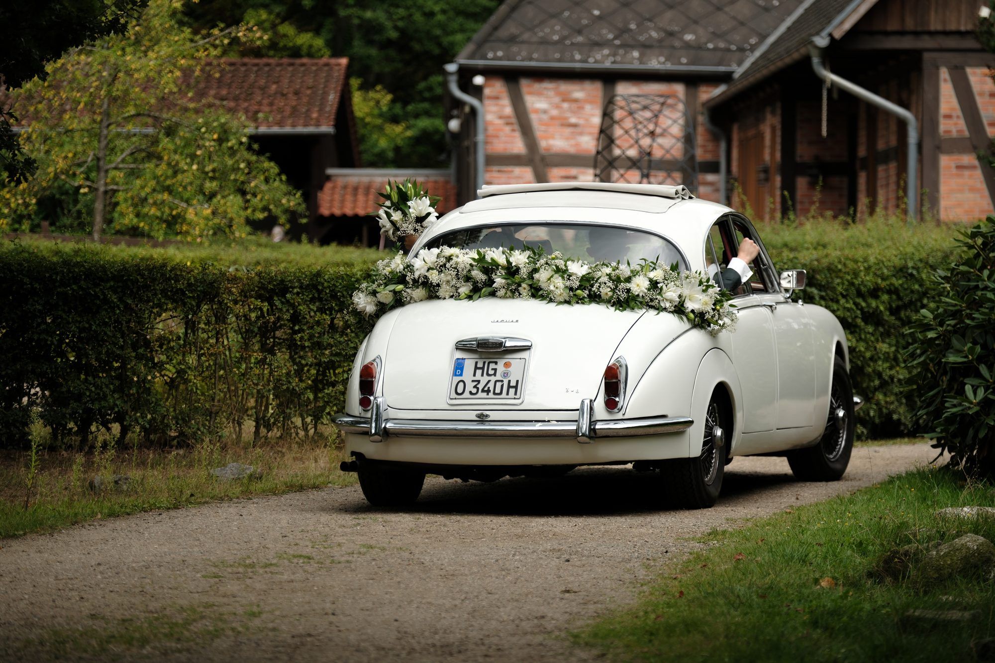 Der geschmückte weiße Oldtimer vor dem Fachwerkhaus